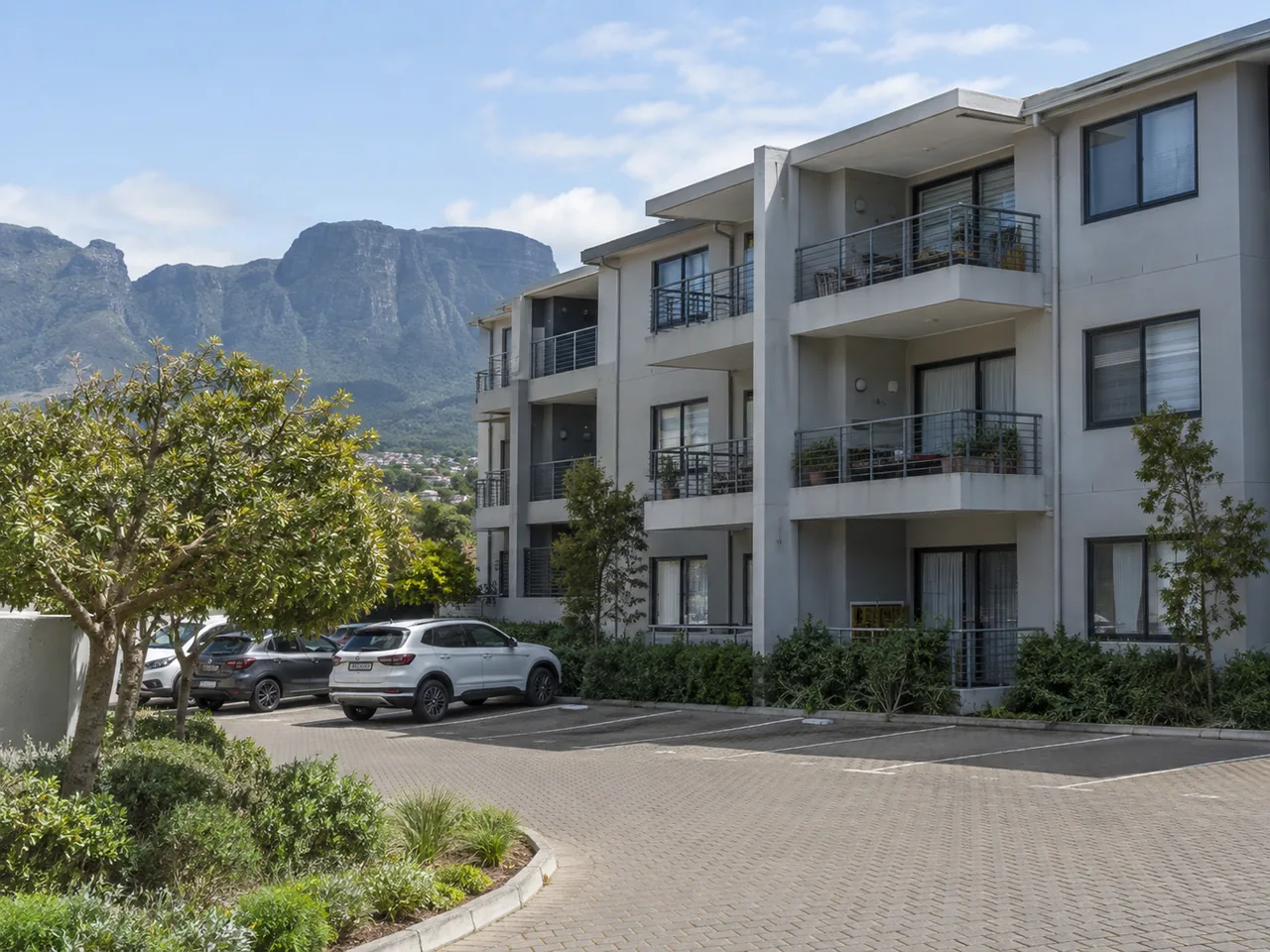 Apartment building with painted exterior walls, balconies and shared parking
