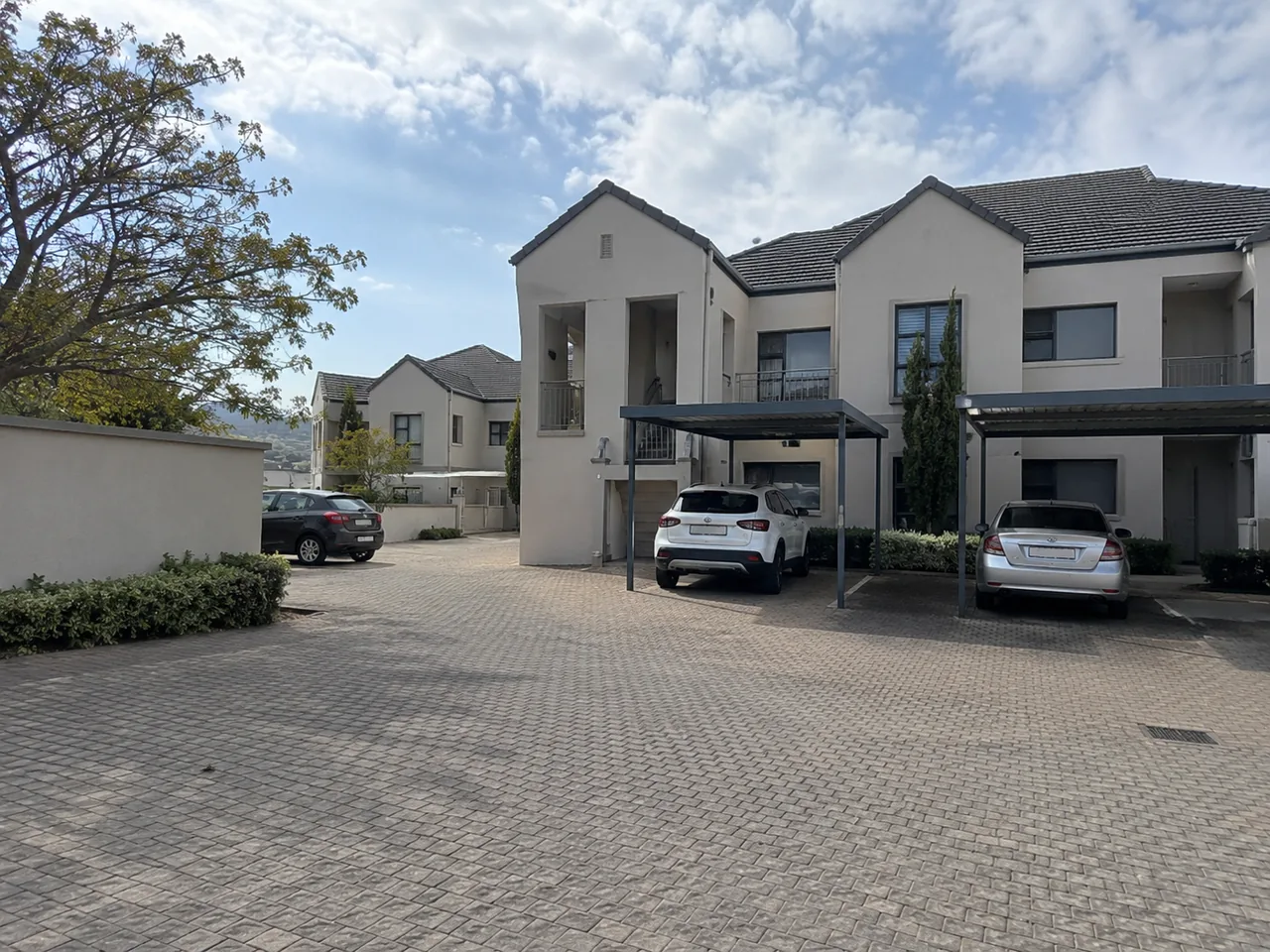 Residential complex with shared paving, rendered facades and pitched roofs