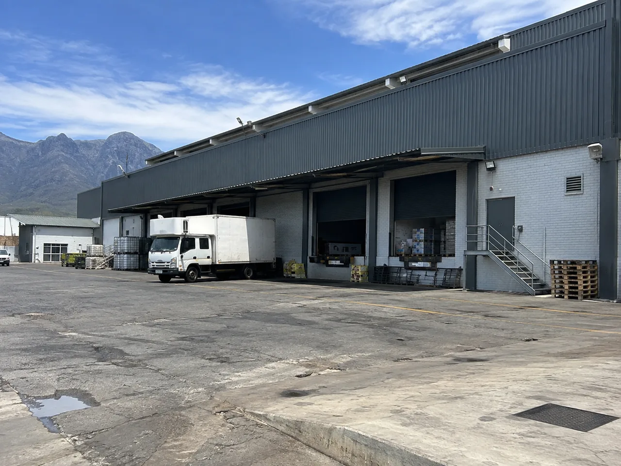 Industrial warehouse with loading bays, metal cladding and a working yard