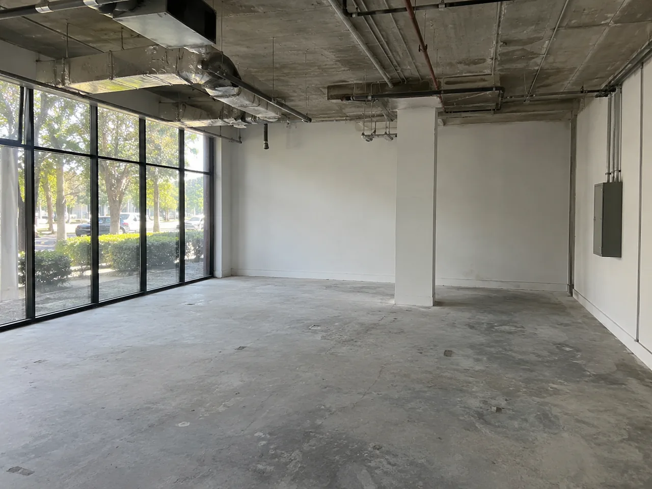 Empty commercial shell with exposed services and unoccupied floor space