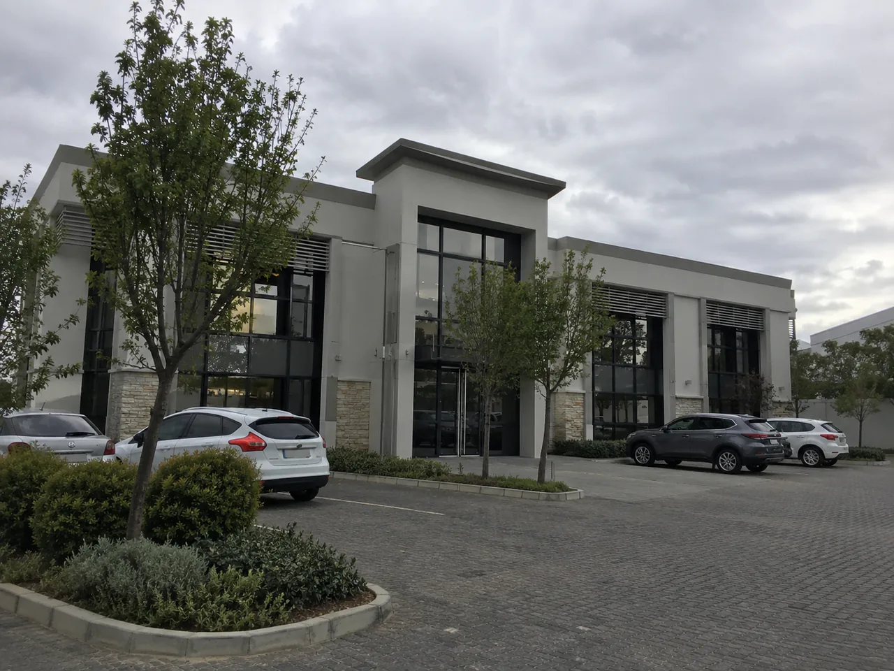 Office park entrance with rendered walls, paving and landscaping