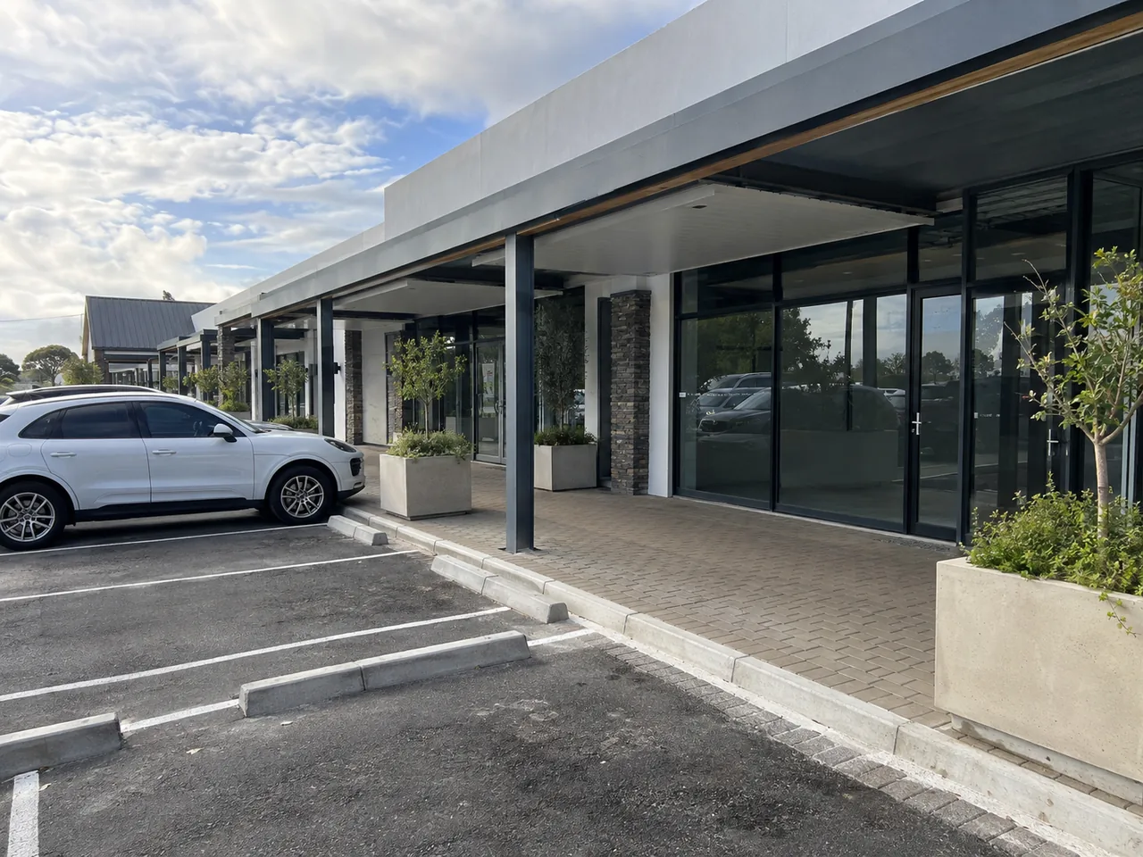 Covered shopfront walkway with painted columns and glazed commercial units