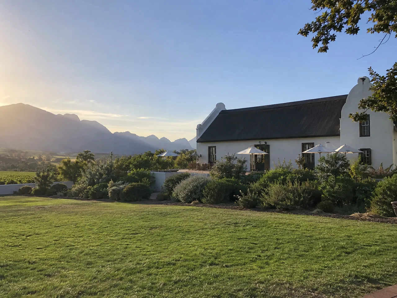 Plastered wine-estate building with a pitched roof and landscaped grounds